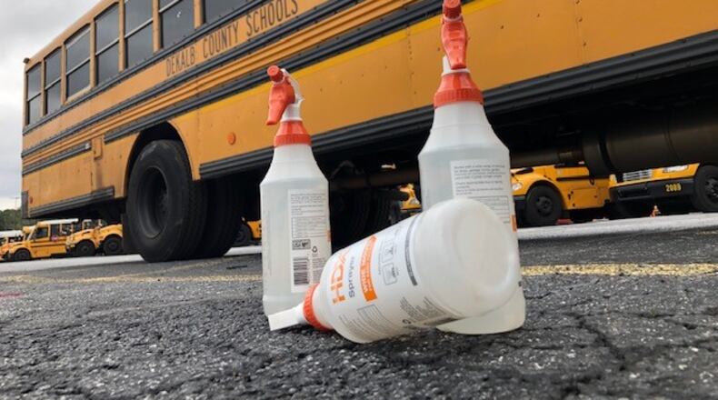 Cleaning supplies sit outside a school bus as bus drivers disinfect the vehicles at DeKalb County School District headquarters in Stone Mountain. (Marlon A. Walker)