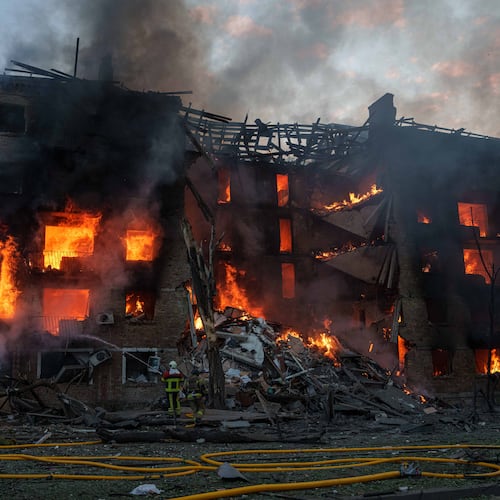 Rescue workers try to put out a fire at a residential building after a Russian strike on Kyiv, Ukraine, Sunday, May 24, 2026. (AP Photo/Evgeniy Maloletka)