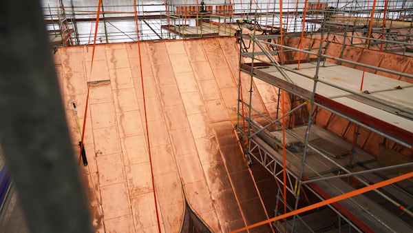 Section of the roof of the fire-damaged Old Stock Exchange building is covered with new coppersmiths in Copenhagen, Denmark, Monday, June 23, 2025. (AP Photo/James Brooks)