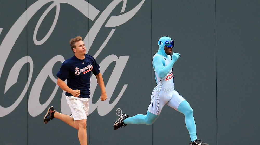 Nigel Talton (right), who was the original "Freeze," races a Braves fan between innings during a game in 2020. (AJC file)