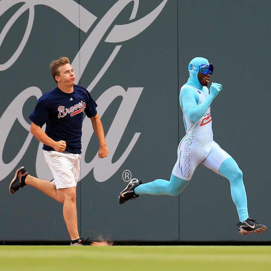 Nigel Talton (right), who was the original "Freeze," races a Braves fan between innings during a game in 2020. (AJC file)