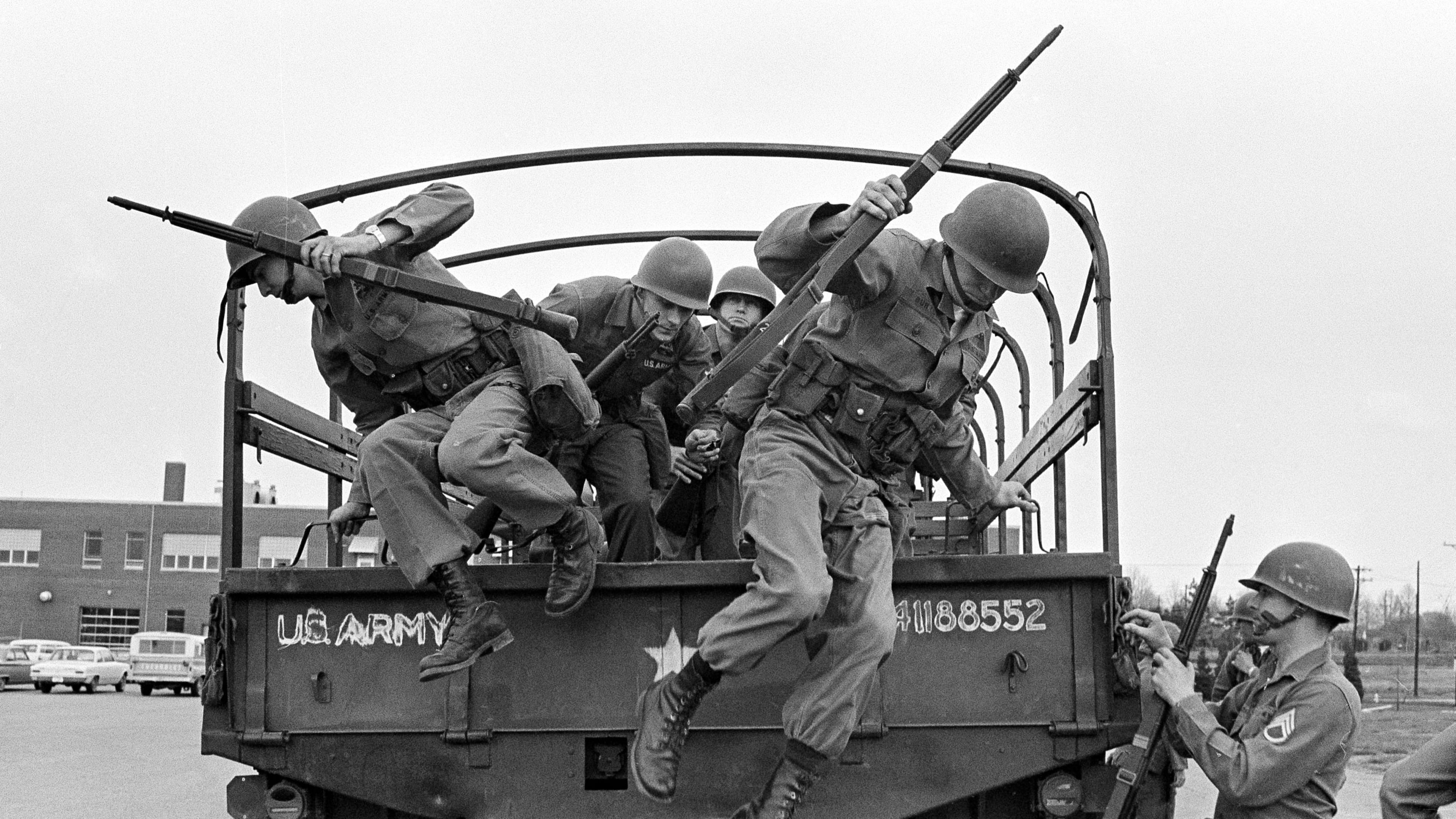 FILE - Tennessee National Guard troops leap out of a truck at the Memphis Armory after being ordered into the city by Gov. Buford Ellington at the request of city officials, March 28, 1968, in Memphis, Tenn. The guard was ordered after rioting and looting erupted midway through a march led by Dr. Martin Luther King Jr. in support of striking garbage workers. (AP Photo/Jack Thornell, File)