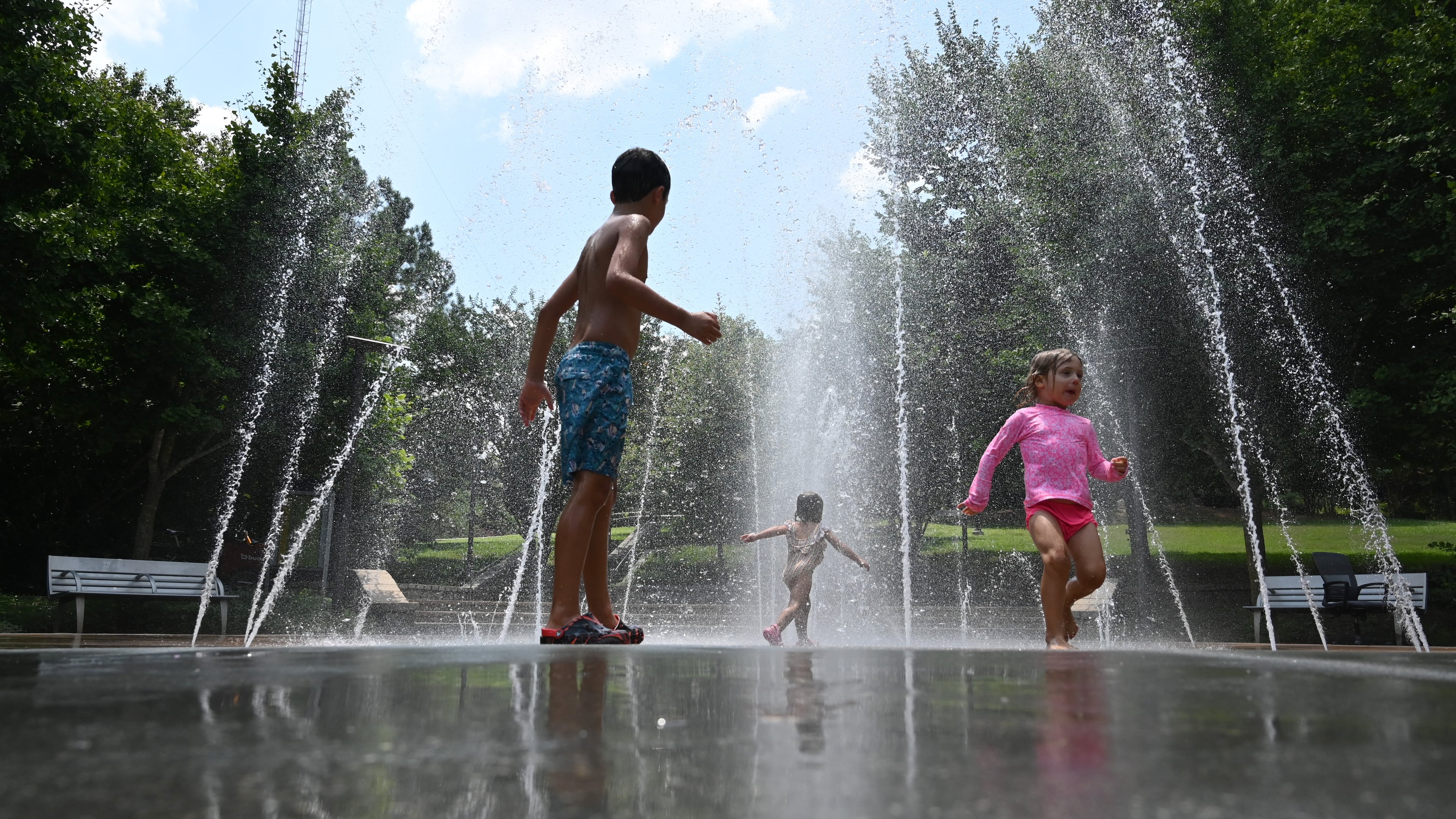 Children cool off in a splash fountain in Atlanta's historic Fourth Ward Park. The forecast for the Fourth of July and the holiday weekend calls for hot days with drier air. (Hyosub Shin/AJC)