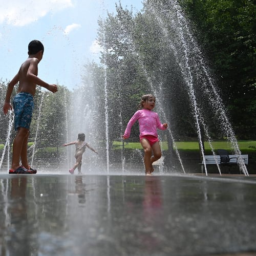 Children cool off in a splash fountain in Atlanta's historic Fourth Ward Park. The forecast for the Fourth of July and the holiday weekend calls for hot days with drier air. (Hyosub Shin/AJC)