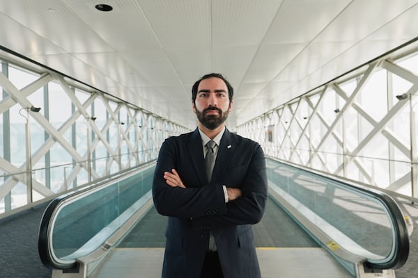 Delta settled with flight attendant Aryasp Nejat, seen on a pedestrian bridge at San Francisco International Airport on March 26, 2026, on “all claims” in August 2025 for an undisclosed amount, admitting no liability. (Felix Uribe Jr. for the AJC) 