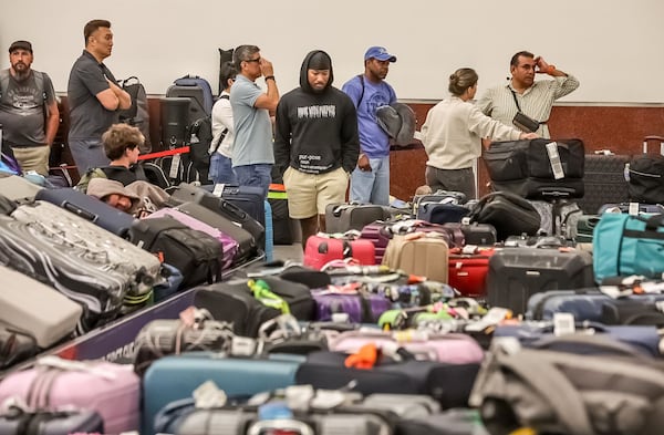Luggage separated from its owners piled up in baggage claim after Delta had to cancel thousands of flights in just a few days. (John Spink/AJC 2024)