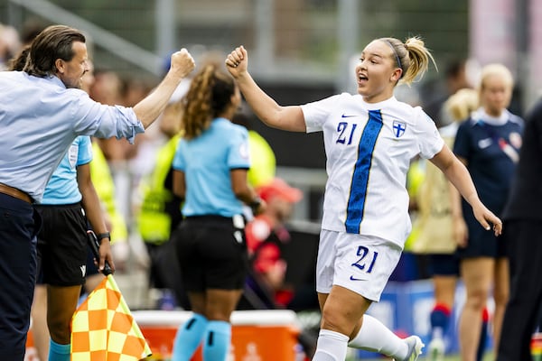 Finland's Oona Sevenius, right, celebrates with Finland's head coach Marko Saloranta, left, after scoring her side's first goal during the Euro 2025, group A, soccer match between Norway and Finland in Sion, Switzerland, Sunday, July 6, 2025. (Jean-Christophe Bott/Keystone via AP)