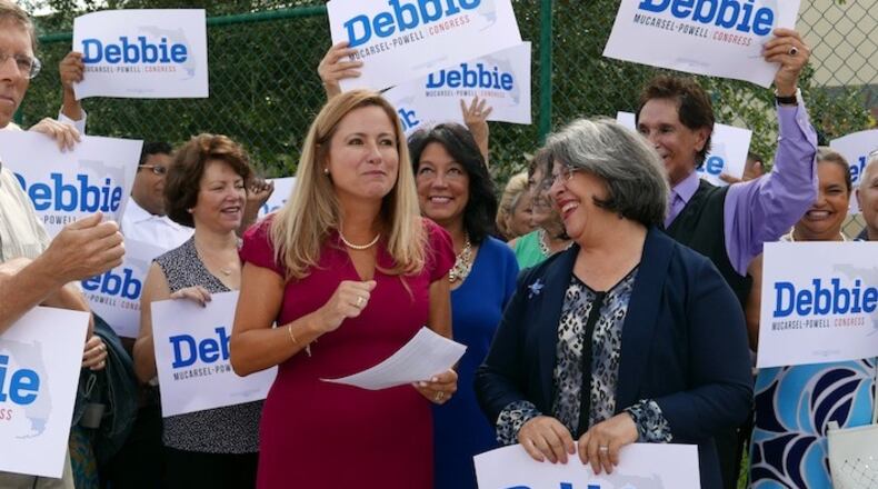 Surrounded by a small group of family and supporters, Democrat Debbie Mucarsel-Powell, middle, wearing red dress, announces she is running against Republican U.S. Rep. Carlos Curbelo, outside the West Perrine Health Center in Miami on Wednesday, Aug. 2, 2017. (Jose A. Iglesias/El Nuevo Herald/TNS)