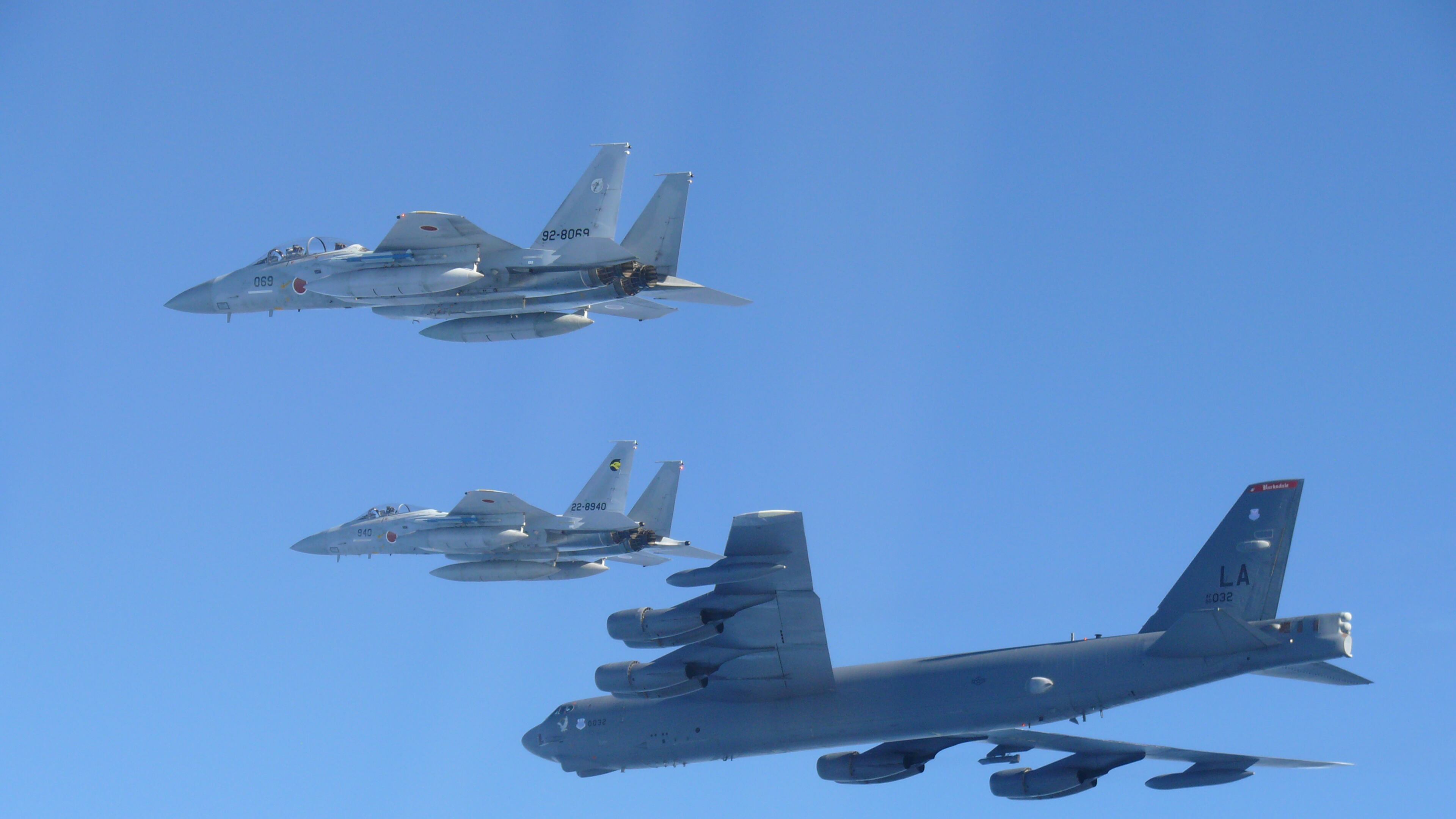 This photo provided by Japan's Ministry of Defense shows the Japan Air Self-Defense Force's F-15 fighters holding a joint military drill with the U.S. B-52 bomber in the vicinity of Japanese airspace on Wednesday Dec. 10, 2025. (Japan's Ministry of Defense via AP)