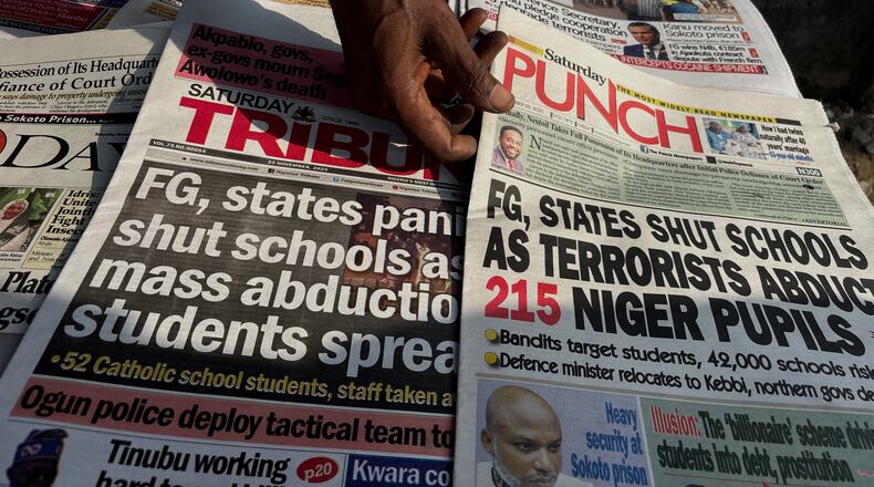 A street vendor in Lagos displays local newspapers with headlines on gunmen abducting schoolchildren and staff of the St. Mary's Catholic Primary and Secondary School in Papiri community in Nigeria, Saturday, Nov. 22, 2025. (AP Photo/Sunday Alamba )
