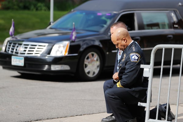 FILE - Police officers, including Minneapolis Police Chief Medaria Arradondo, foreground, take a knee as the body of George Floyd arrives before his memorial services in Minneapolis on June 4, 2020. (AP Photo/Julio Cortez, File)