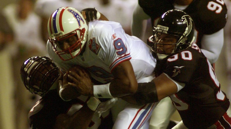 980807 ATLANTA: Oilers' quarterback Steve McNair (9,cq) drags three Falcons along with him as he scrambles upfield for a first down in second quarter action at the Georgia Dome in preseason action 8/7/98. The players holding onto McNair are Cornelius Bennet (L), Chuck Smith (R), and Lester Archambeau (92, all cq). (DAVID TULIS/Staff)