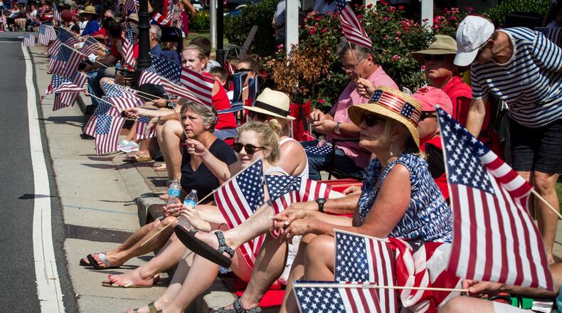 Spectators wave their flags as the Marietta Freedom Parade in Marietta. Steve Schaefer/Special to the AJC