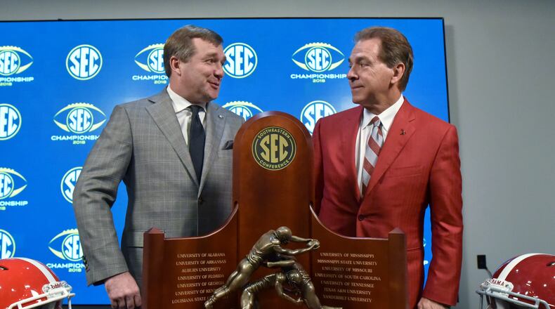 Georgia coach Kirby Smart and Alabama coach Nick Saba pose in front of the championship trophy during a SEC news conference at Mercedes-Benz Stadium on Friday, November 30, 2018. HYOSUB SHIN / HSHIN@AJC.COM