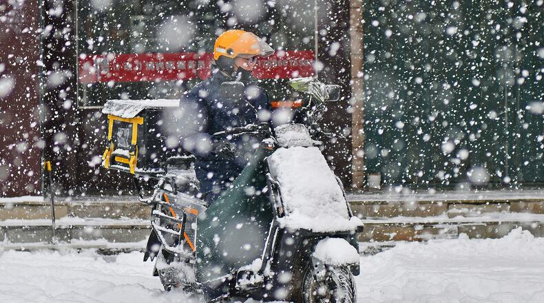FILE: A food delivery rider is braving the snow in Yantai, Shandong Province, China, on December 20, 2023. (Photo by Costfoto/NurPhoto via Getty Images)