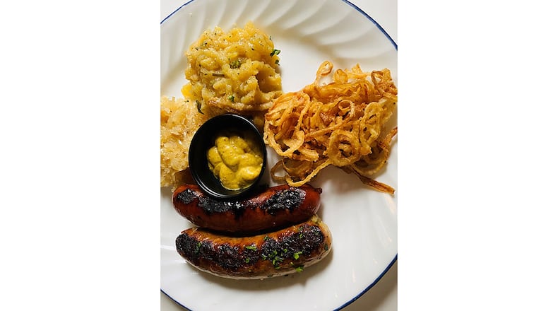 Kurt's offers a sausage skillet with sauerkraut, German potato salad and onion straws. Bob Townsend/For The AJC
