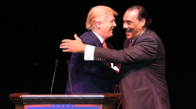 Donald Trump gets a hug from Bruce Levell. AJC/Curtis Compton.