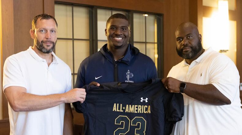 Pace Academy senior Trovon Baugh received his commemorative 2023 Under Armour Next All-America Game jersey on Friday, Oct. 14. He is pictured with Pace Academy Head Coach Nick Bach (left) and Assistant Coach Kevin Johnson (right).