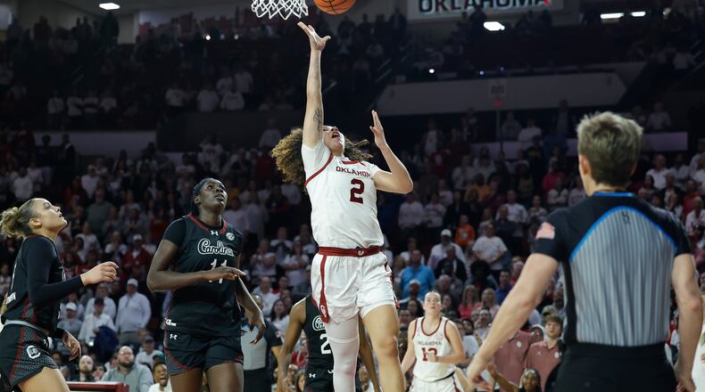 Oklahoma guard Aaliyah Chavez (2) goes up for a basket beside South Carolina center Madina Okot (11) during overtime of a NCAA college basketball game Thursday, Jan. 22, 2026 in Norman, Okla. (AP Photo/Alonzo Adams)