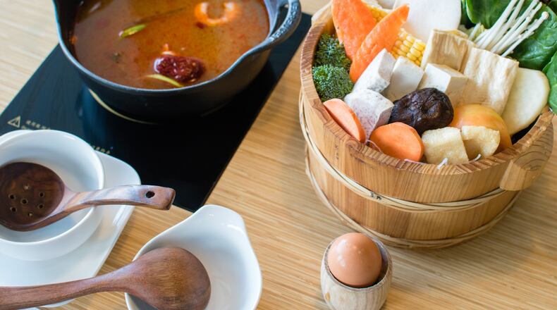 A hotpot meal with herbal broth (left) and the vegetarian entree (right) at J's Mini Hotpot Deluxe. CONTRIBUTED BY HENRI HOLLIS