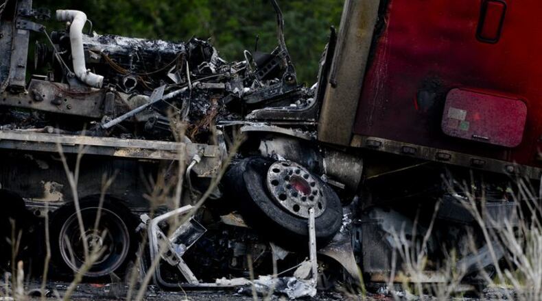 A tractor trailer sits on top of a crushed car after a multiple car accident on I-16 in Pooler, Ga. on Tuesday, May 19, 2015. (Ian Maule/Savannah Morning News via AP)
