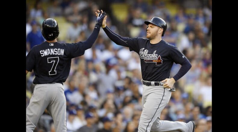 Dansby Swanson and Freddie Freeman (right) both scored on a two-out double from Tyler Flowers in Saturday night’s 5-3 win against the Dodgers. (AP Photo/Mark J. Terrill)