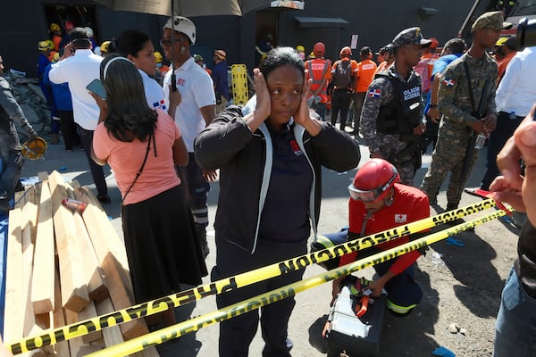 A woman stands outside the Jet Set nightclub after its roof collapsed during a merengue concert in Santo Domingo, Dominican Republic, Tuesday, April 8, 2025. (AP Photo/Ricardo Hernandez)