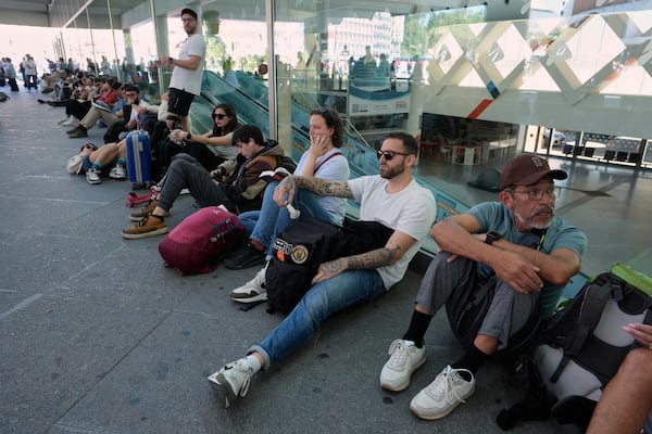 Passengers wait outside Atocha train station during a nationwide power outage in Madrid, Monday, April 28, 2025. (AP Photo/Manu Fernandez)