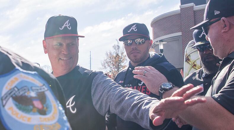 Braves manager Brian Snitker (left) and first baseman Freddie Freeman (center) greet fans before the start of the home opener Monday, April 1, 2019, against the Chicago Cubs at SuntTrust Park in Atlanta.