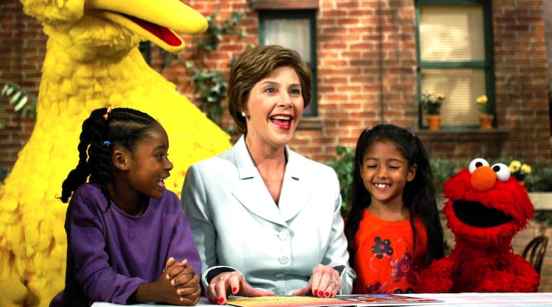 First lady Laura Bush, center, reads a book to Sydney Martinez, left, Big Bird, background, Sienna Jerries and Elmo, right, as they tape a segment on the Sesame Street children's show promoting reading Thursday, Sept. 19, 2002, in New York. (AP Photo/Beth A. Keiser)