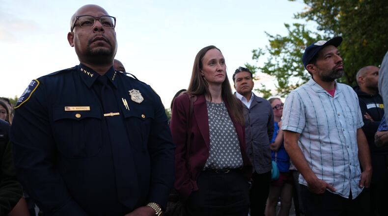 Seattle Mayor Katie Wilson, center, and Seattle Police Chief Shon Barnes, left, attend the vigil for victims the day after a shooting at Seattle Center during the Bite of Seattle food festival, Monday, July 27, 2026, in Seattle. (AP Photo/Lindsey Wasson)