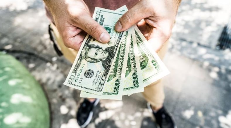 Photo illustration of a man holding money. According to WHBQ, 420 employees of the city of Memphis, Tennessee, are about to get a raise to an hourly rate that is more than twice the state and federal minimum wage average.