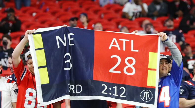 111821 Atlanta: Patriots fans hold a sign reminding Falcons fans of their blown Super Bowl loss to the Patriots during their current 25-0 shut out in Mercedes-Benz Stadium sporting many empty seats in a NFL football game on Thursday, Nov. 18, 2021, in Atlanta. “Curtis Compton / Curtis.Compton@ajc.com”
