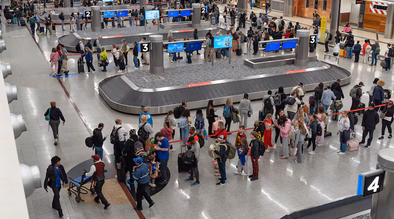 Security checkpoint lines were long enough to snake into baggage claim at Hartsfield-Jackson Atlanta International Airport on Monday. (Ben Hendren for the AJC)