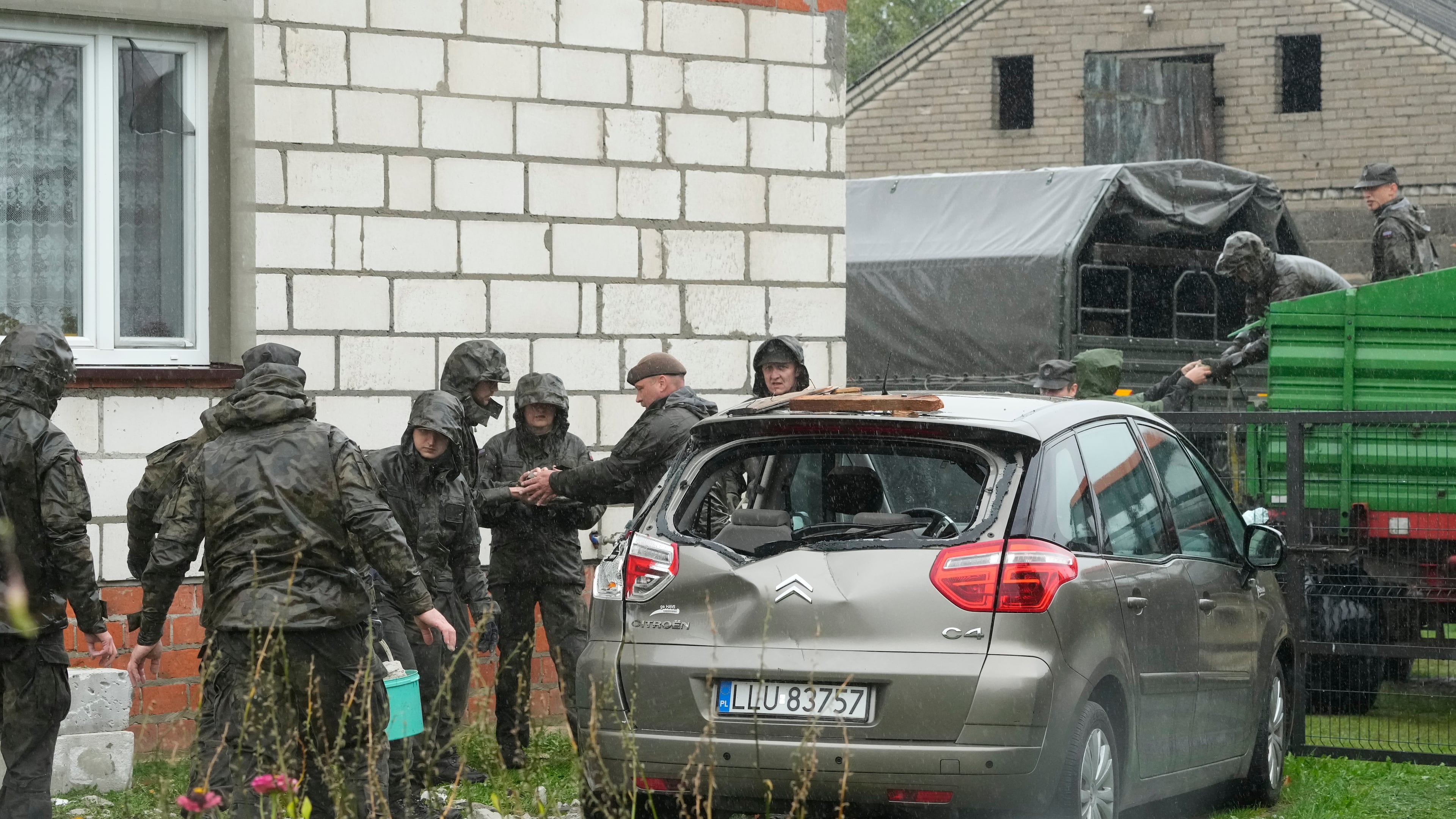 Territorial defense officers clean up debris from the destroyed roof of a house, after Russian drones violated Polish airspace during an attack on Ukraine, in Wyryki near Lublin, Poland, Thursday, Sept. 11, 2025. (AP Photo/Czarek Sokolowski)