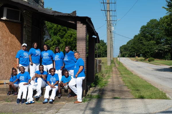 Former residents of the "One Square Mile" community and their relatives gather on Wednesday, July 9, 2025, at the former Price’s Barbershop in College Park. The group, known as PHOAA, plans to create a museum for the community there starting this summer. Harvard Avenue, where the building sits, was once a thriving main street for the African American community before residents were pushed out due to increasing airport noise. (Ben Gray for The Atlanta Journal-Constitution)