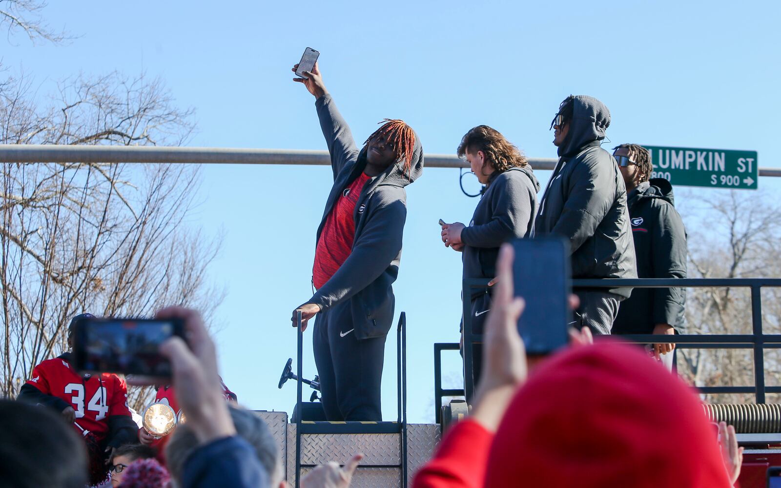 A member of the football team takes a selfie with fans during the University of Georgia National Championship victory parade on Saturday, January 14, 2023, in Athens, Georgia. The Dawgs waved to fans as they rode down Lumpkin Street. CHRISITNA MATACOTTA FOR THE ATLANTA JOURNAL-CONSTITUTION.