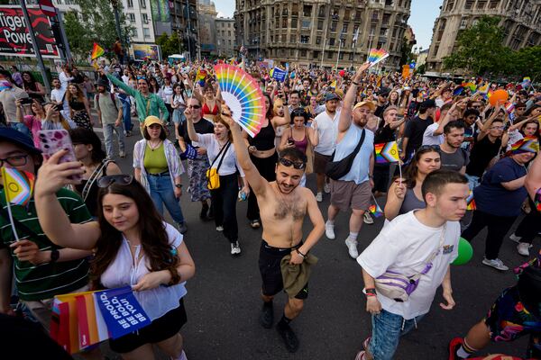 People dance while holding rainbow flags during the Bucharest Pride Parade, in Bucharest, Romania, Saturday, June 7, 2025. (AP Photo/Andreea Alexandru)