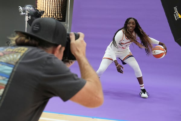 Phoenix Mercury guard-forward Kahleah Copper, right, dribbles the ball in front of team photographer Barry Gossage during a photo shoot at Mercury Media Day at the team's WNBA basketball training facility, Wednesday, April 30, 2025, in Phoenix. (AP Photo/Ross D. Franklin)