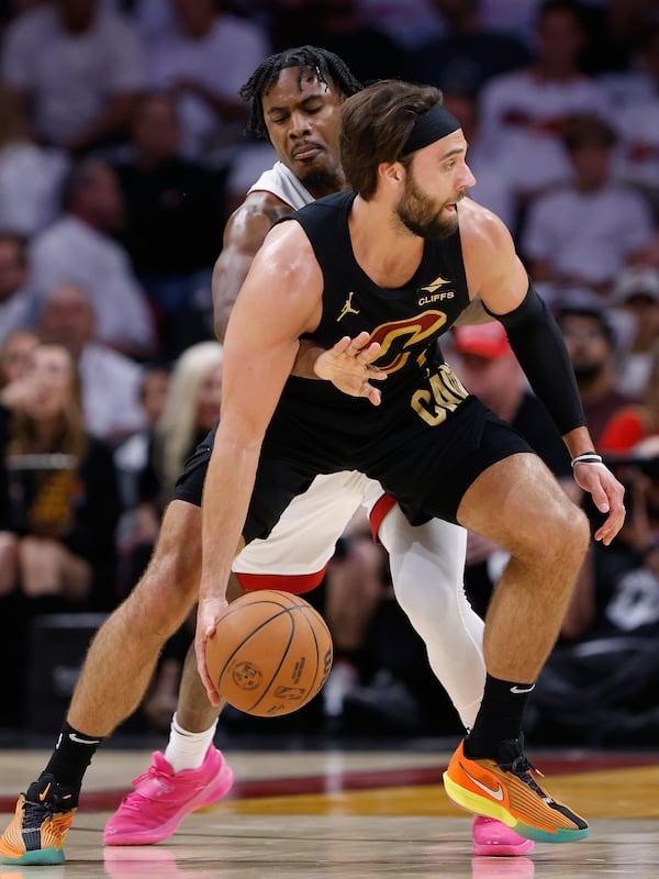 Miami Heat guard Davion Mitchell, back, tries to knock the ball away from Cleveland Cavaliers guard Max Strus, front, during the first half in Game 4 of an NBA basketball first-round playoff series, Monday, April 28, 2025, in Miami. (AP Photo/Rhona Wise)
