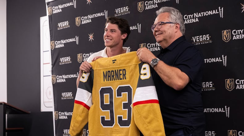 FILE - Newly-acquired Golden Knights forward Mitch Marner, left, poses for a photo with his jersey alongside general manager Kelly McCrimmon, July 1, 2025, in Las Vegas. (Chase Stevens/Las Vegas Review-Journal via AP, File)