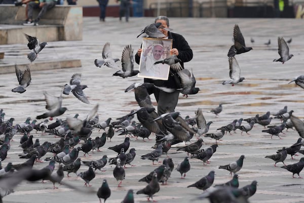 Ana Diaz sells posters of the late Pope Francis near the Cathedral in Bogota, Colombia, Saturday, April 26, 2025. (AP Photo/Fernando Vergara)