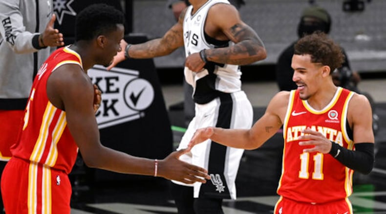 Atlanta Hawks' Trae Young (11) and Clint Capela celebrate the team's double-overtime victory against the San Antonio Spurs in an NBA basketball game Thursday, April 1, 2021, in San Antonio. Atlanta won 134-129. (AP Photo/Darren Abate)