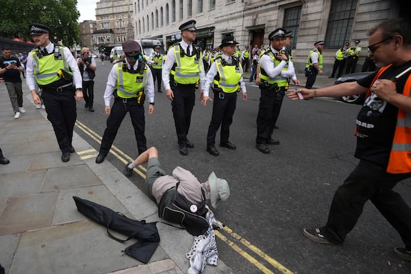 A demonstrator lies on the ground in front of a police line during a protest by Palestine Action group in London, Monday, June 23, 2025. (AP Photo/Frank Augstein)