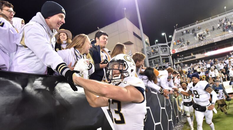 In the aftermath of a rare win over Miami, Georgia Tech wide receiver Brad Stewart (83) celebrates with fans at Bobby Dodd Stadium. (HYOSUB SHIN / HSHIN@AJC.COM)