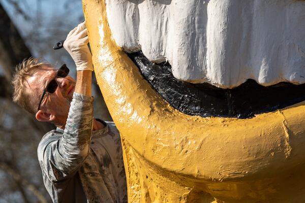 Plains resident Michael Dominick paints the Smiling Peanut in Plains on Sunday, February 19, 2023. (Arvin Temkar / arvin.temkar@ajc.com)