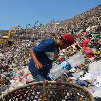 Komaruddin, a waste picker, looks for recyclable items in a pile of garbage at the Bantargebang landfill on the outskirts of Jakarta, Indonesia, Monday, July 6, 2026. (AP Photo/Tatan Syuflana)