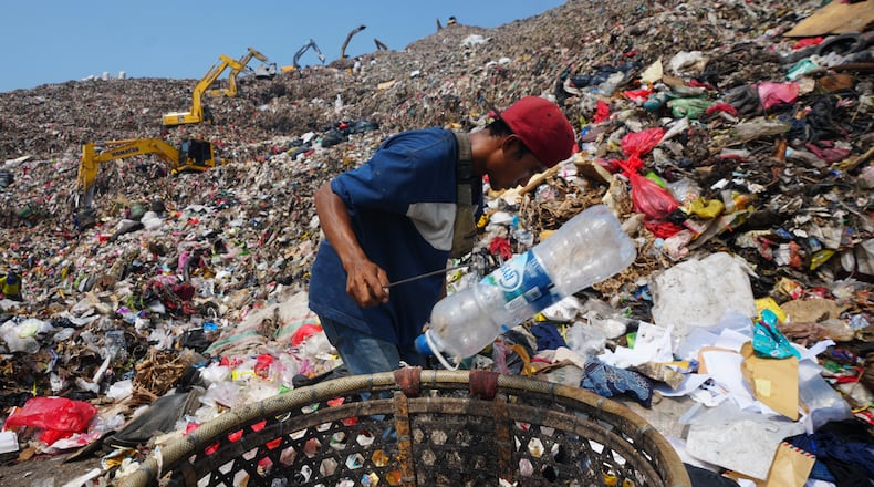 Komaruddin, a waste picker, looks for recyclable items in a pile of garbage at the Bantargebang landfill on the outskirts of Jakarta, Indonesia, Monday, July 6, 2026. (AP Photo/Tatan Syuflana)