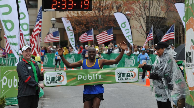 Abraham Kogo, of Hebron, Ky., wins first place in the Publix Georgia Marathon with a time of 2:33:21 as he crosses the finish line at Centennial Olympic Park Sunday, March 23, 2014, in Atlanta. David Tulis / AJC Special