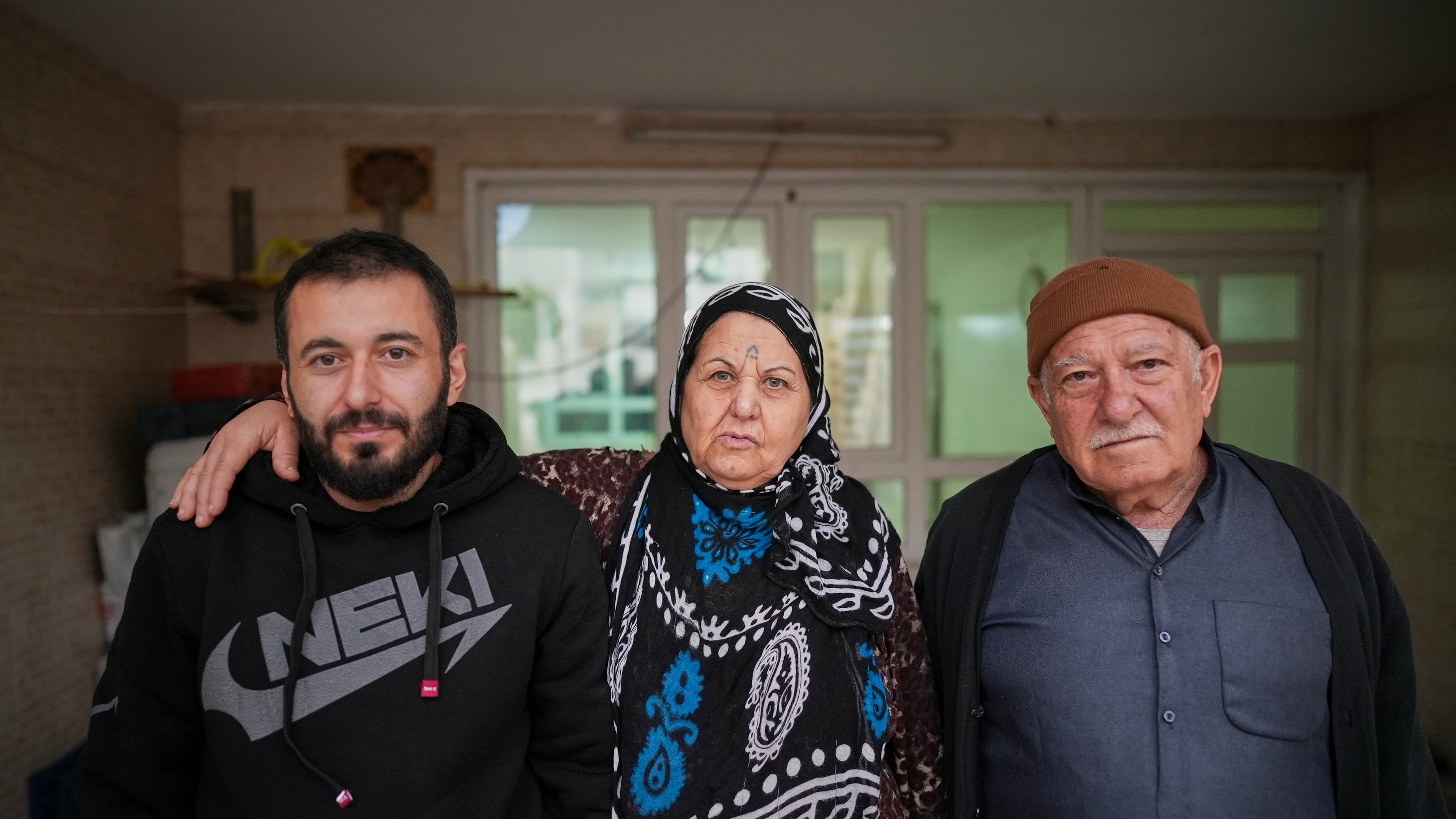 Syrian refugee Mohammed Dawood, 30, left, poses for a photo with his parents, Hayat Fatah, 65, center, and Abdulilah Amin Dawoud, 73, at their home in Irbil, Iraq, Nov. 16, 2025. (AP Photo/Farid Abdulwahed)